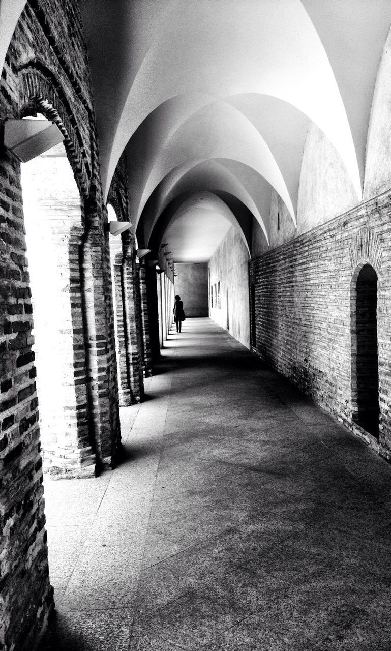 arch, architecture, built structure, indoors, the way forward, corridor, architectural column, diminishing perspective, colonnade, in a row, history, archway, travel destinations, famous place, vanishing point, building exterior, incidental people, walkway, travel