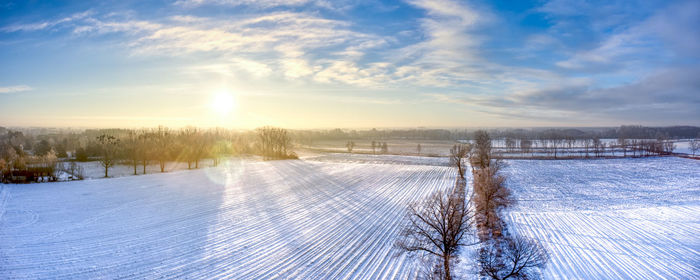 Scenic view snow covered field against sky