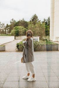 Rear view of woman standing against trees