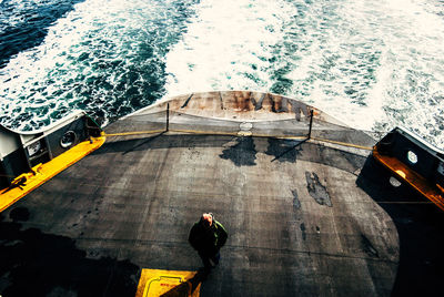 High angle view of man standing on boat in sea