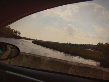 Boat sailing on river against sky