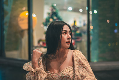 Portrait of young woman looking away outdoors