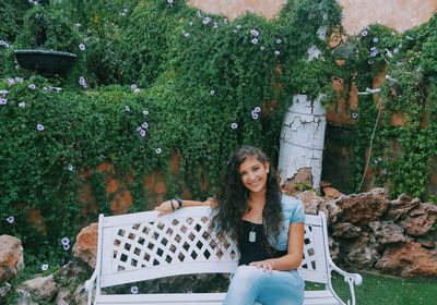 Portrait of smiling young woman sitting outdoors