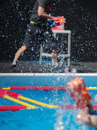 Person splashing water swimming in pool