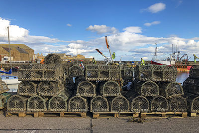 Stack of fishing net against sky in city