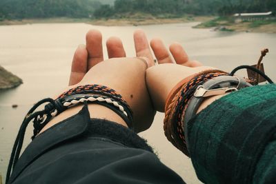 Cropped image of couple holding hands at beach