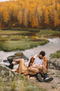 Happy people in love are travel hike in nature in the autumn forest. romantic trip to countryside