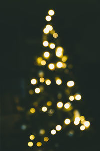 Defocused image of illuminated christmas tree at night