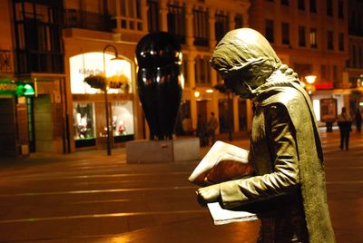 Side view of woman in city at night