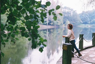 Portrait of woman standing by lake