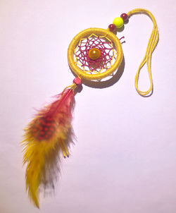 Close-up of yellow decoration hanging on white background