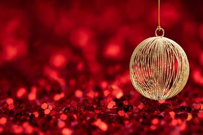 Close-up of christmas ornament hanging over sequins