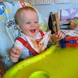 Portrait of happy baby boy sitting on sofa