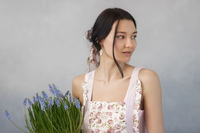 Smiling woman looking away while standing against wall