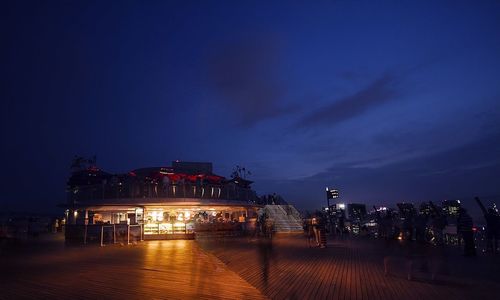 Illuminated cityscape against sky at night