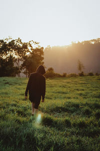 Rear view of man walking on field