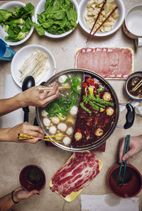 Cropped hands having food at table