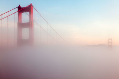 Low angle view of suspension bridge against sky during sunset