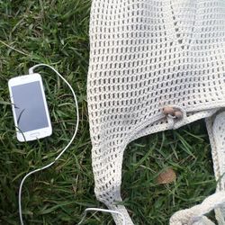 Directly above shot of bag and mobile phone on field