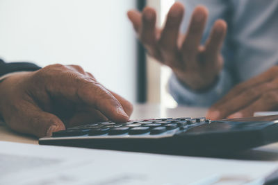 Close-up of man using laptop on table