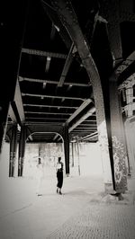 Rear view of people walking on bridge in city