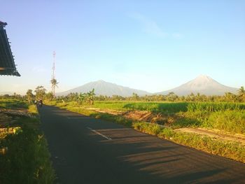 Road leading towards mountains against sky