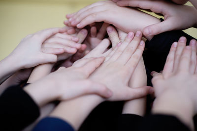 Cropped hands of friends against wall