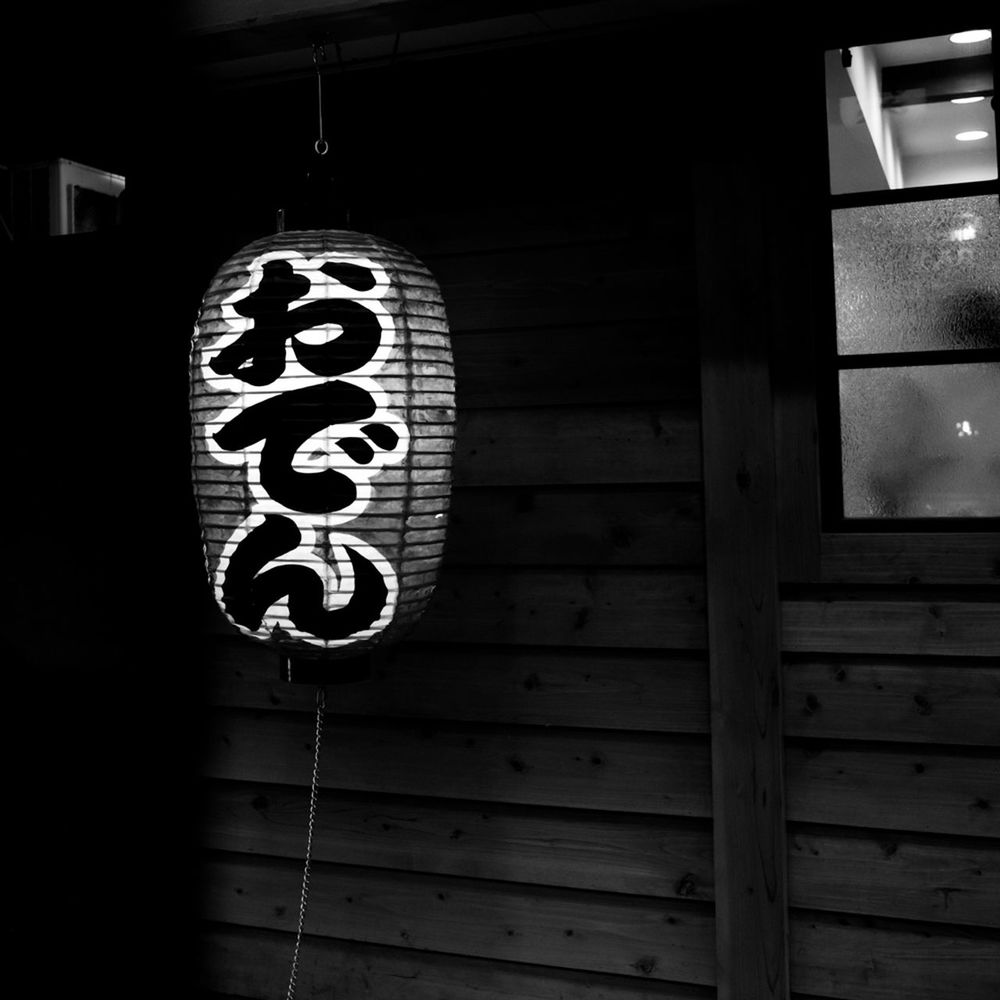 black, white, darkness, light, black and white, no people, lighting equipment, architecture, hanging, monochrome photography, monochrome, built structure, communication, lighting, illuminated, text, wood, low angle view, building exterior, night, outdoors, lantern