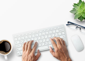 Cropped hands of woman using laptop on table