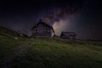 House on field against sky at night