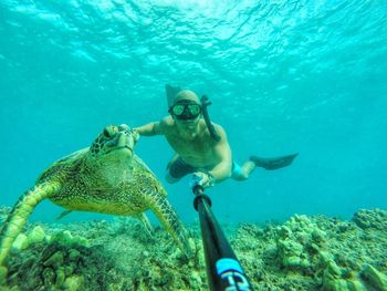 Man snorkeling with sea turtle