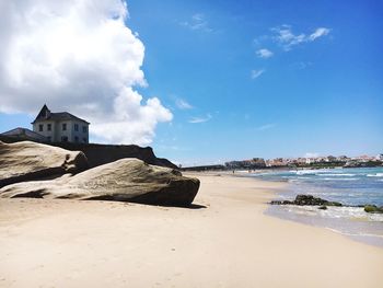 Beach by buildings against sky