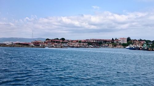 Scenic view of sea by city against sky