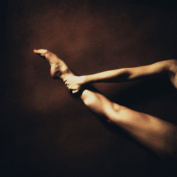 Cropped image of woman performing gymnastics against wall