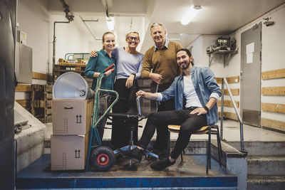 Portrait of smiling business people with equipment in new office