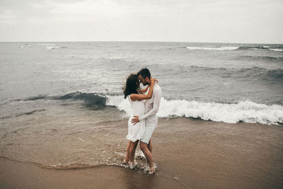 Woman standing on beach against sea