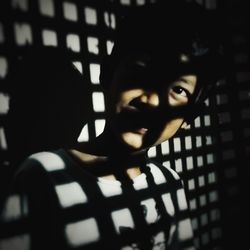 Close-up portrait of boy with shadow of window