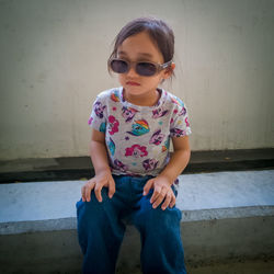 Full length of girl sitting on wall