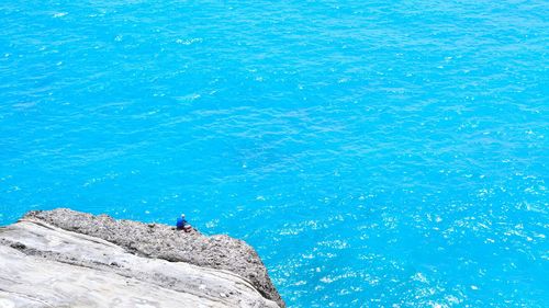 High angle view of man on rock in sea