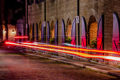 Abstract view of modern city car lights on a bumpy road next to an old brick building