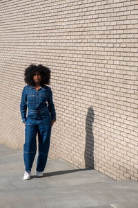 Rear view of woman standing against wall