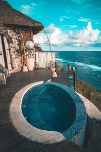 Swimming pool by sea against sky