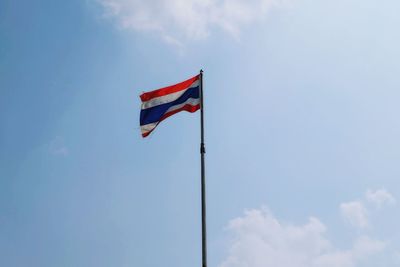 Low angle view of american flag against blue sky