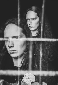 Portrait of woman standing by fence