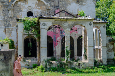 Woman standing by old building