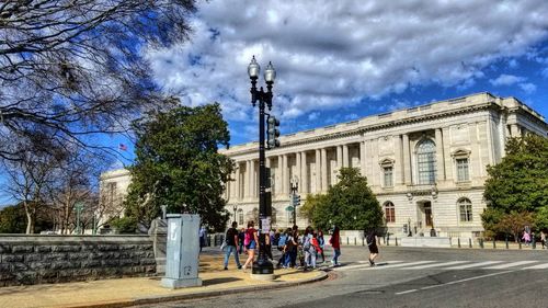 People in front of building against sky