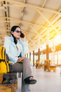 Young woman looking away while sitting on seat