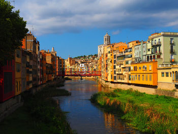 Canal amidst houses against sky in city