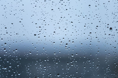 Low angle view of raindrops on window