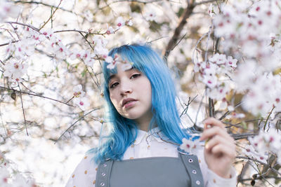 Portrait of woman with pink flowers on branch